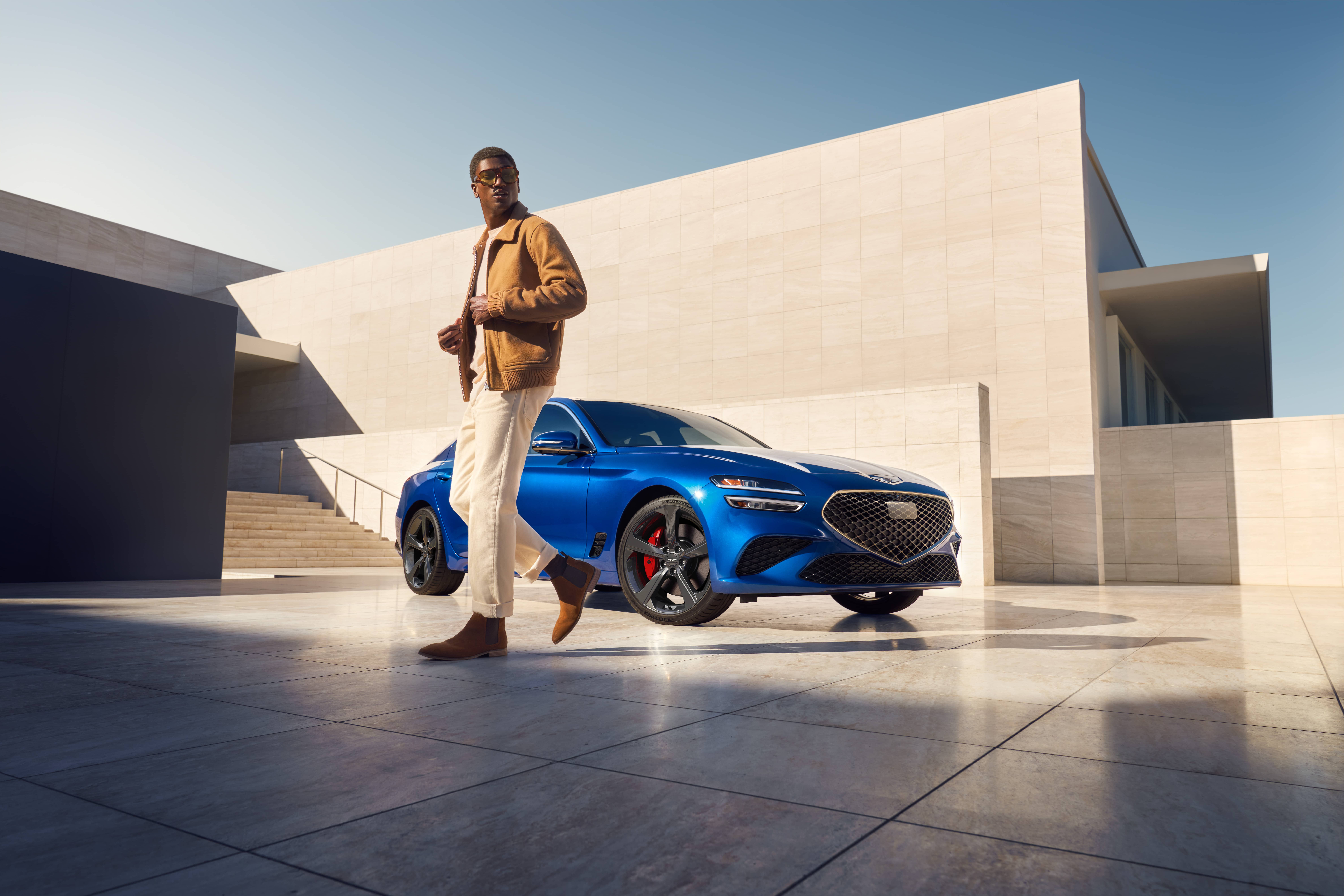 man standing outside parked genesis g70