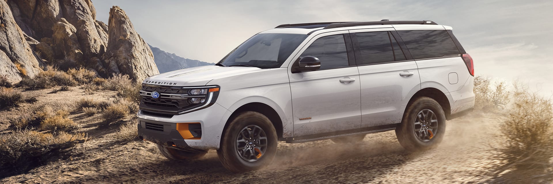 A Ford Bronco driving thru a dessert.