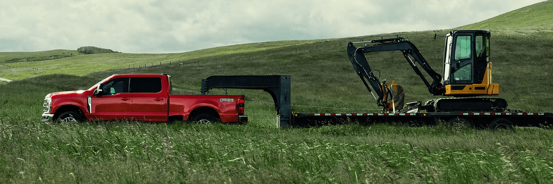A Ford Super Duty F-350 towing heavy machinery