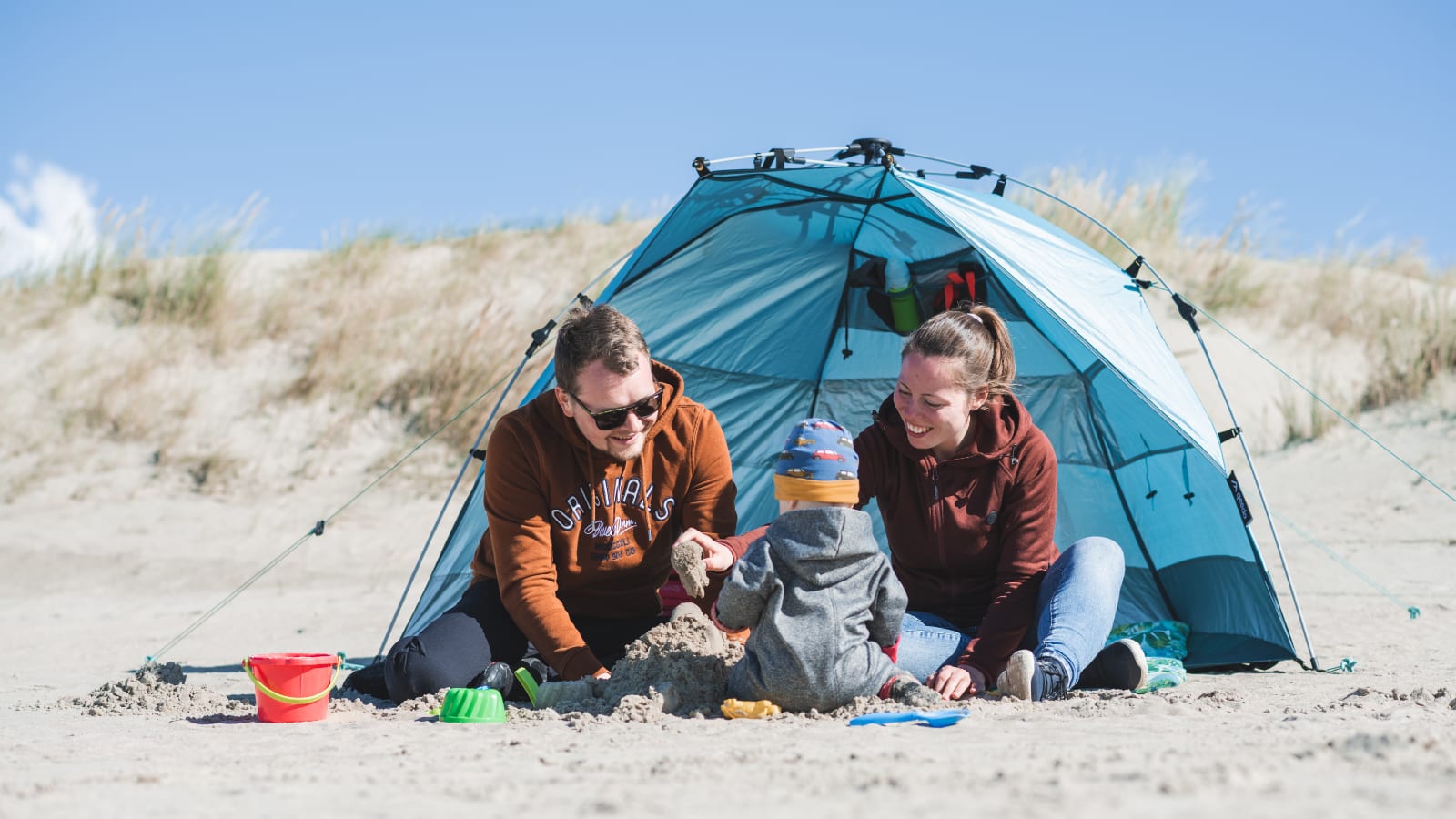 familie_sitzt_in_qeedo_strandzelt