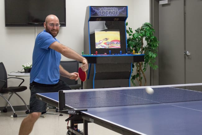 an employee playing table tennis in the breakroom