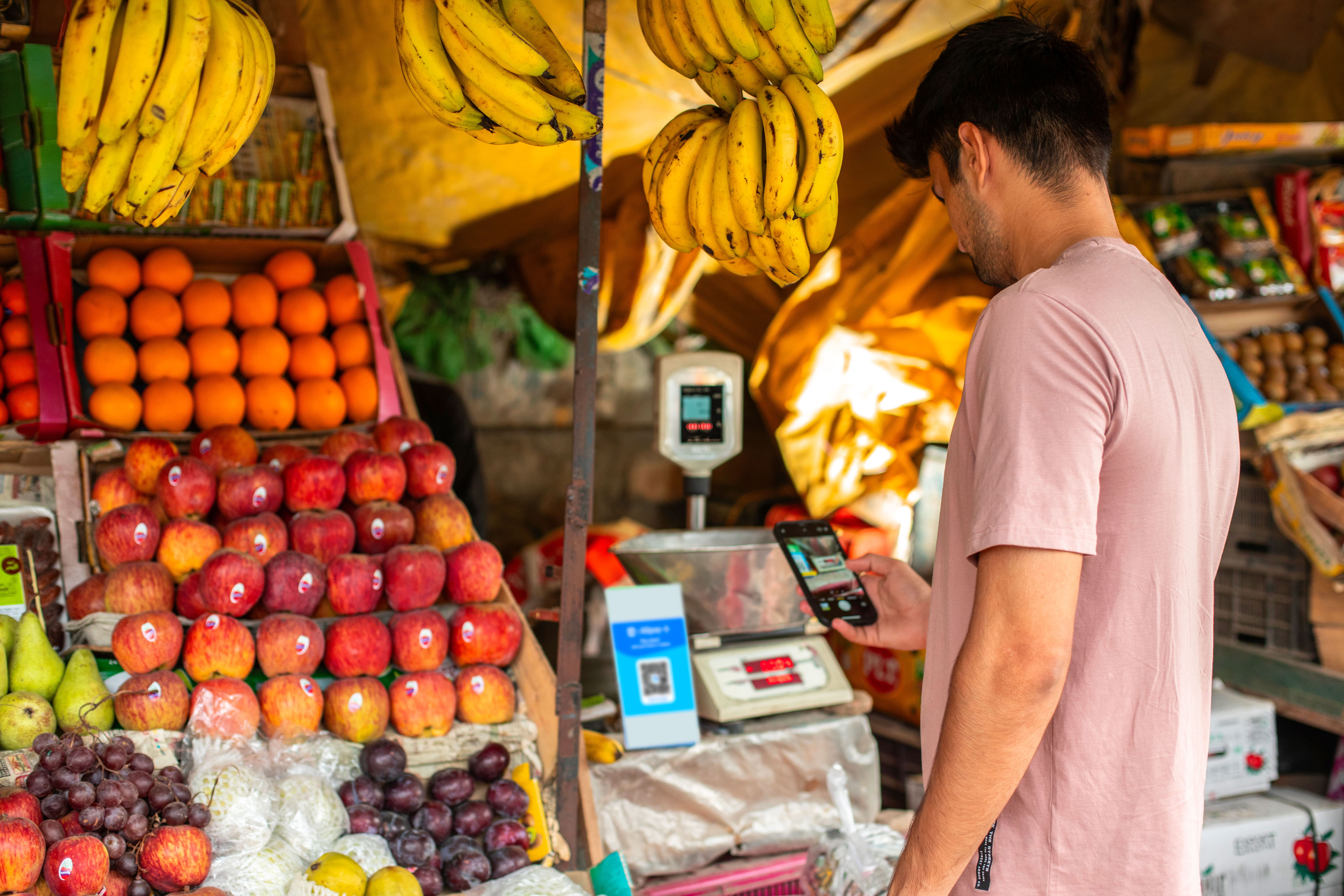 Man scanning an Alipay+ QR code at the market