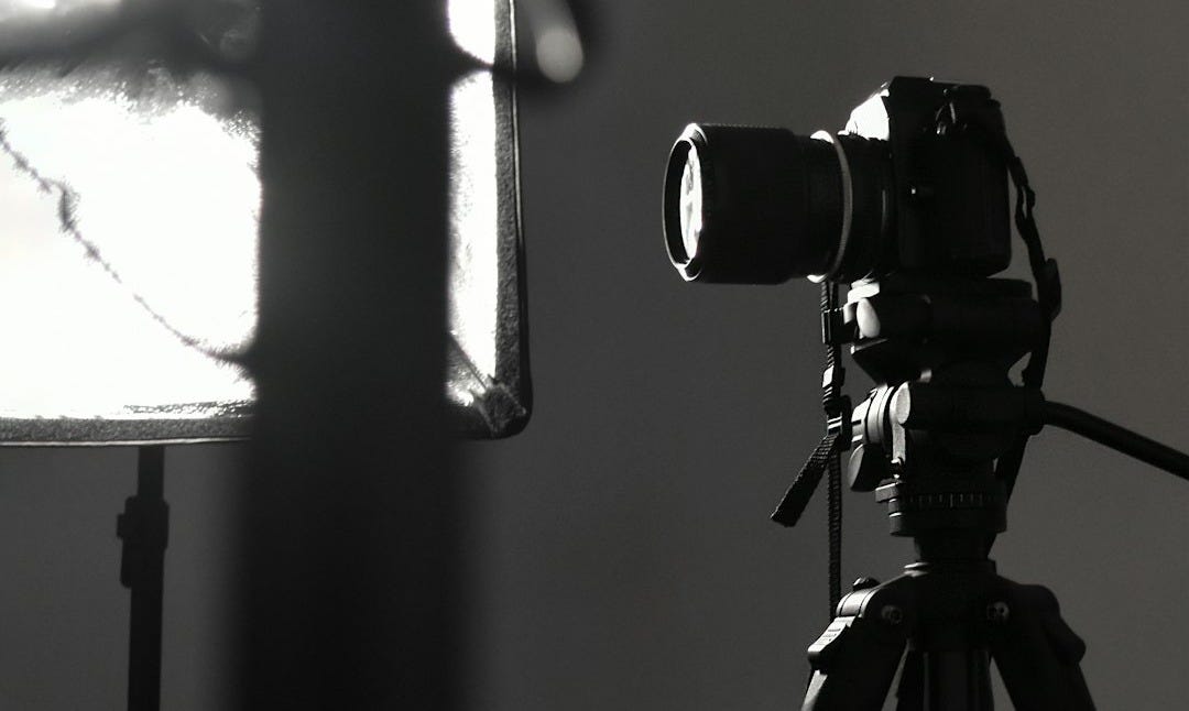 black camera on tripod in grayscale photography