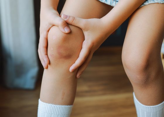 Child holding painful knee