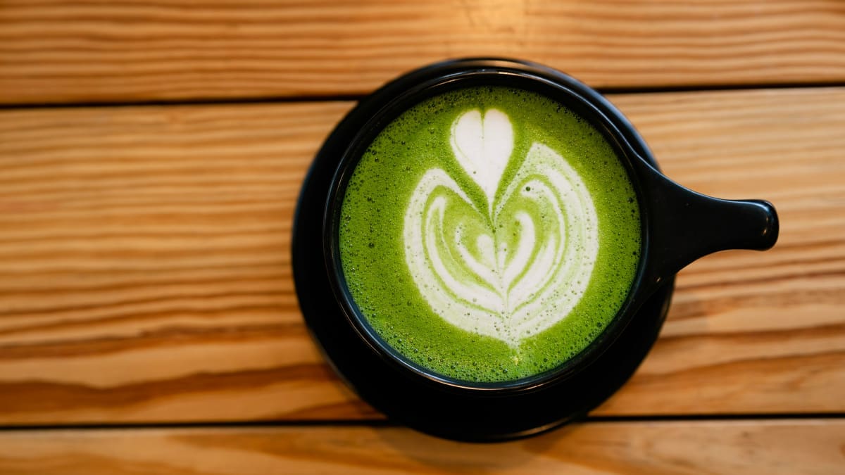 Matcha latte with frothed milk in a dark mug