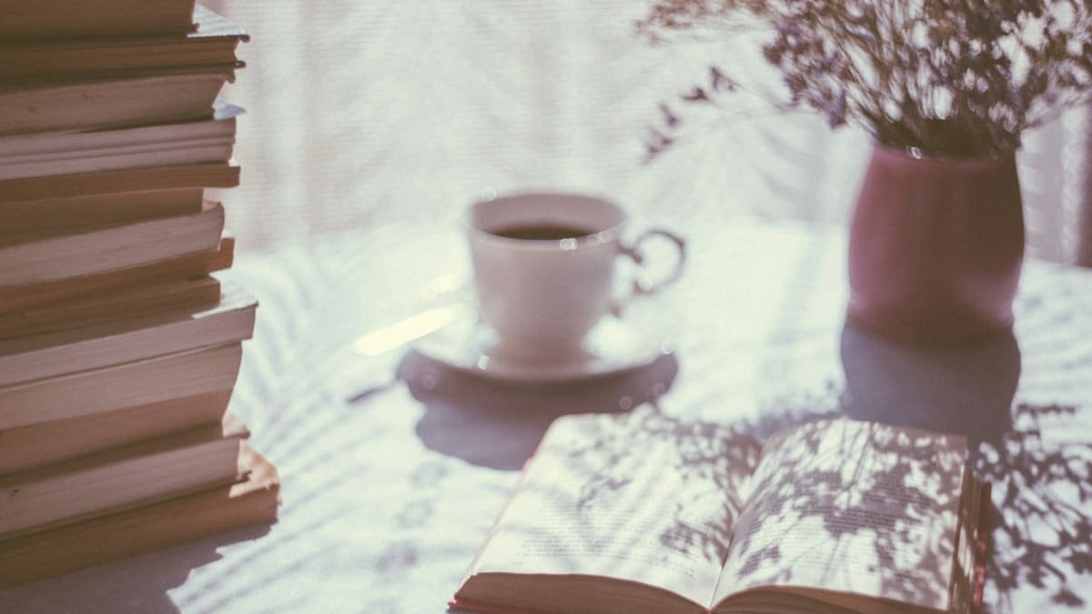 Famous tea quotes: an open book beside a white teacup on a saucer