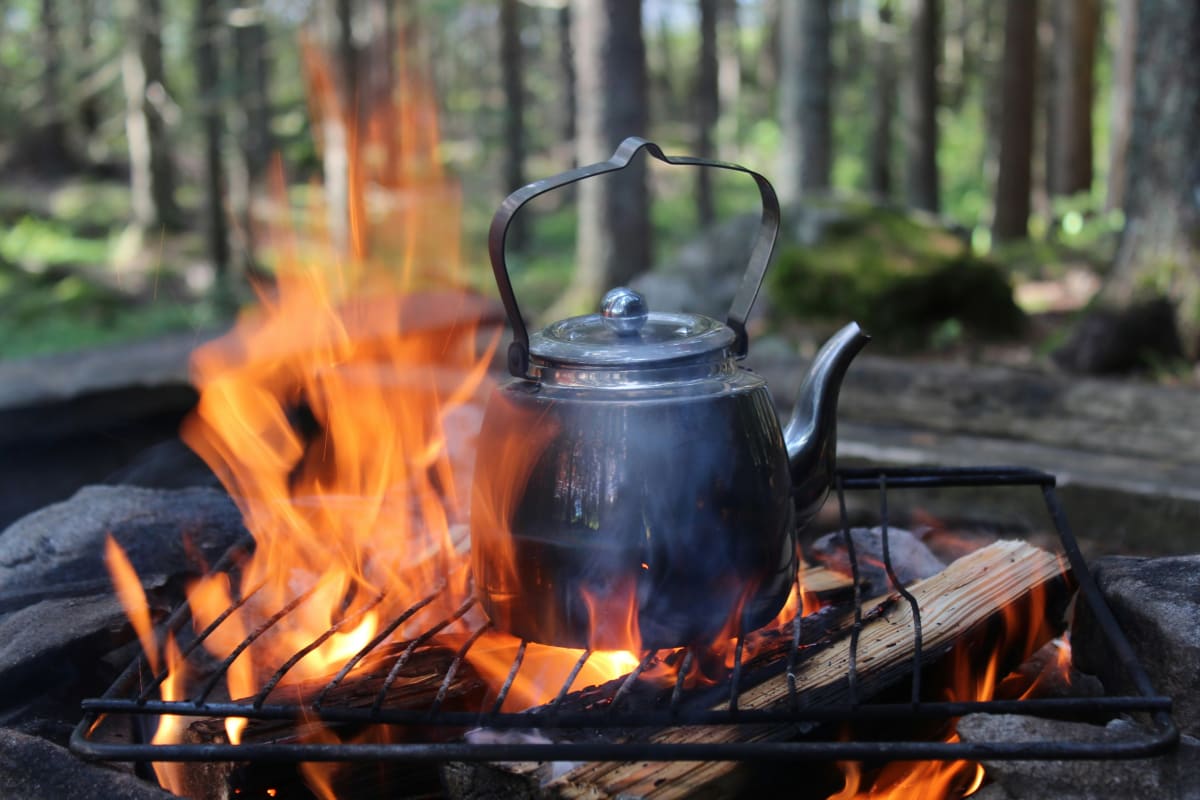 Black kettle heating over a campfire