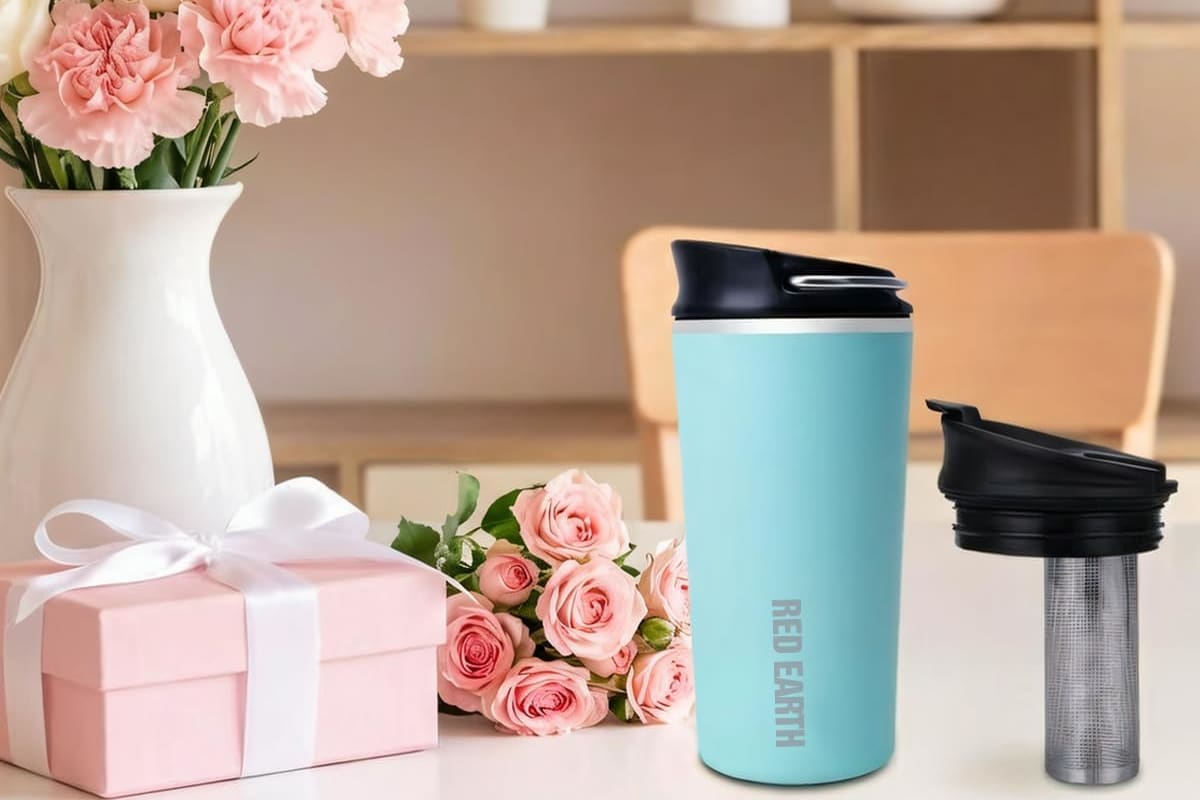 Travel tea mug with its removable infuser on a table