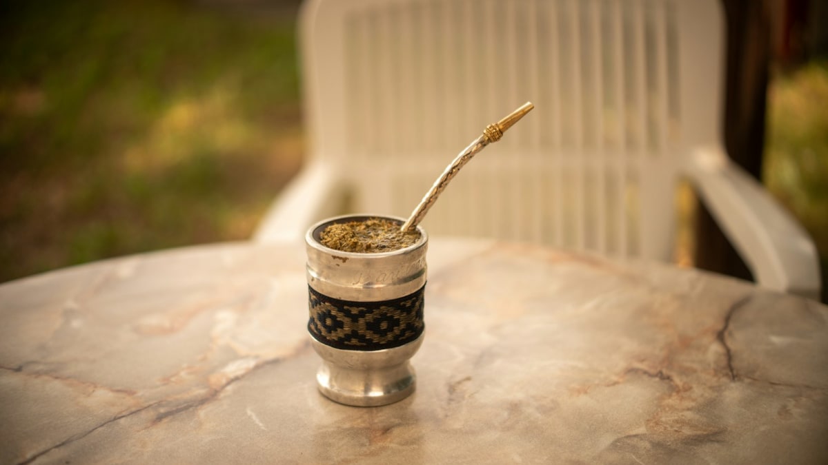 Silver alpaca bombilla resting in a mate cup on a marble table