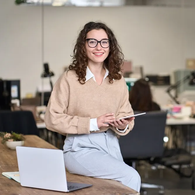 Senhora sentada em uma mesa a segurar uma tablet
