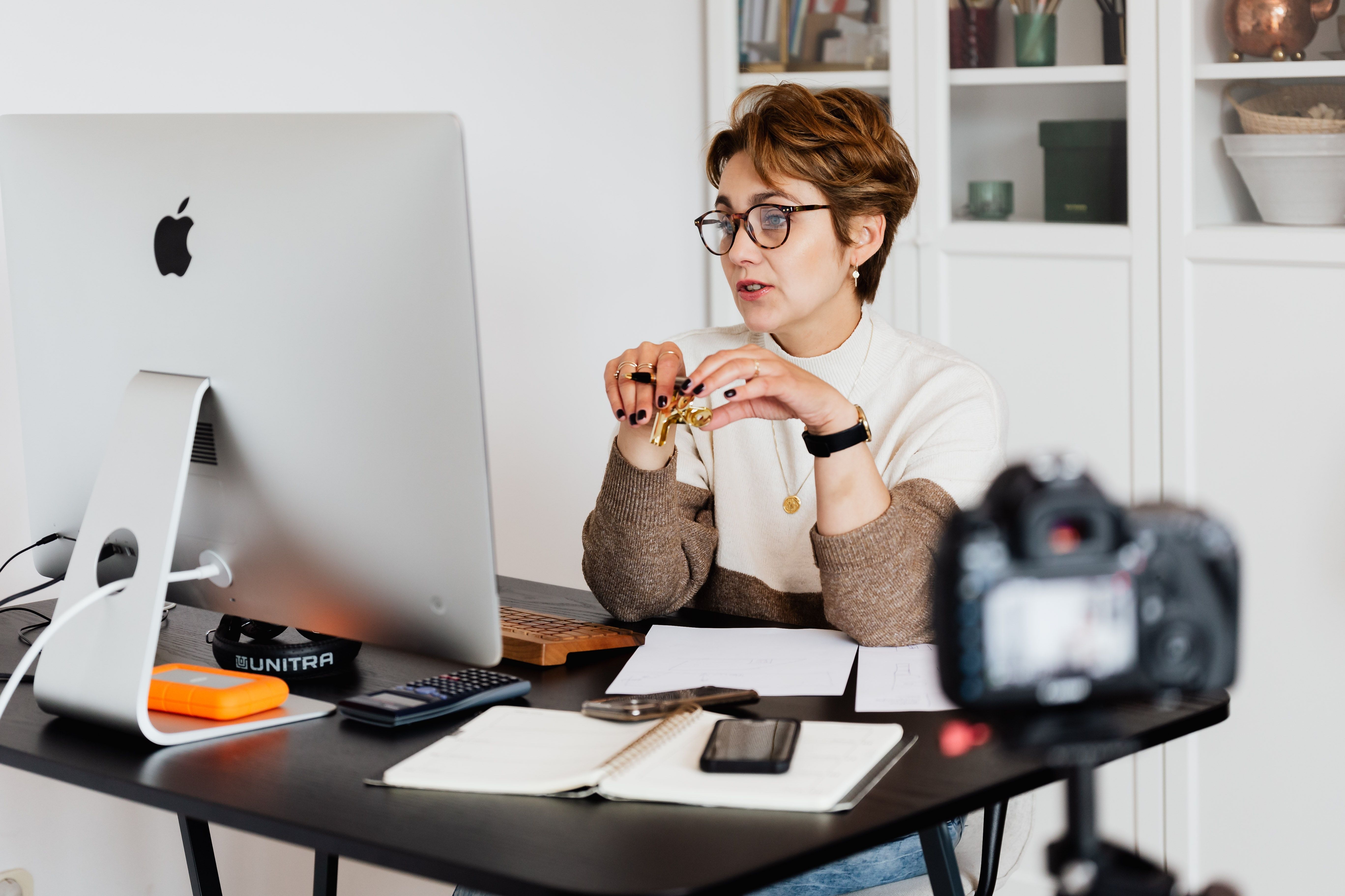 A woman is sitting behind a computer, leading a webinar. A woman is sitting behind a computer, leading a webinar.