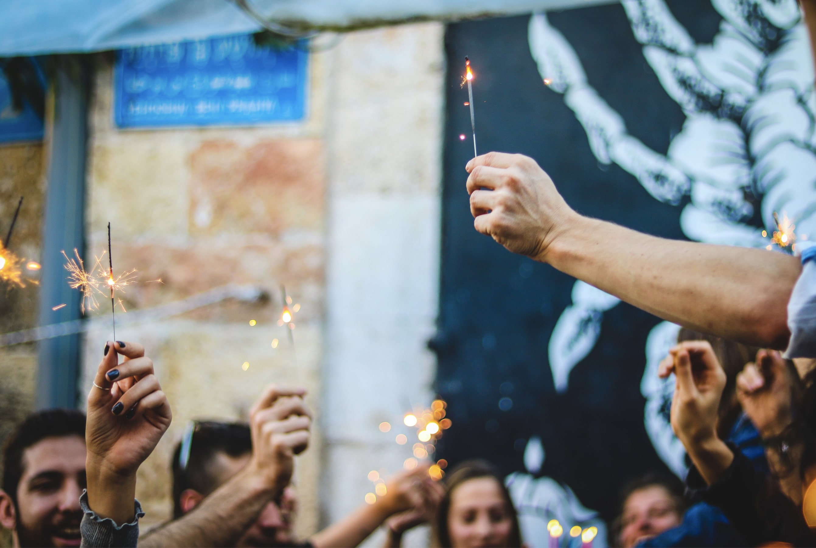 People are holding sparklers while celebrating birthday in the company. People are holding sparklers while celebrating birthday in the company.