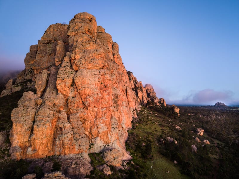 Close on the sandstone face as first light hits