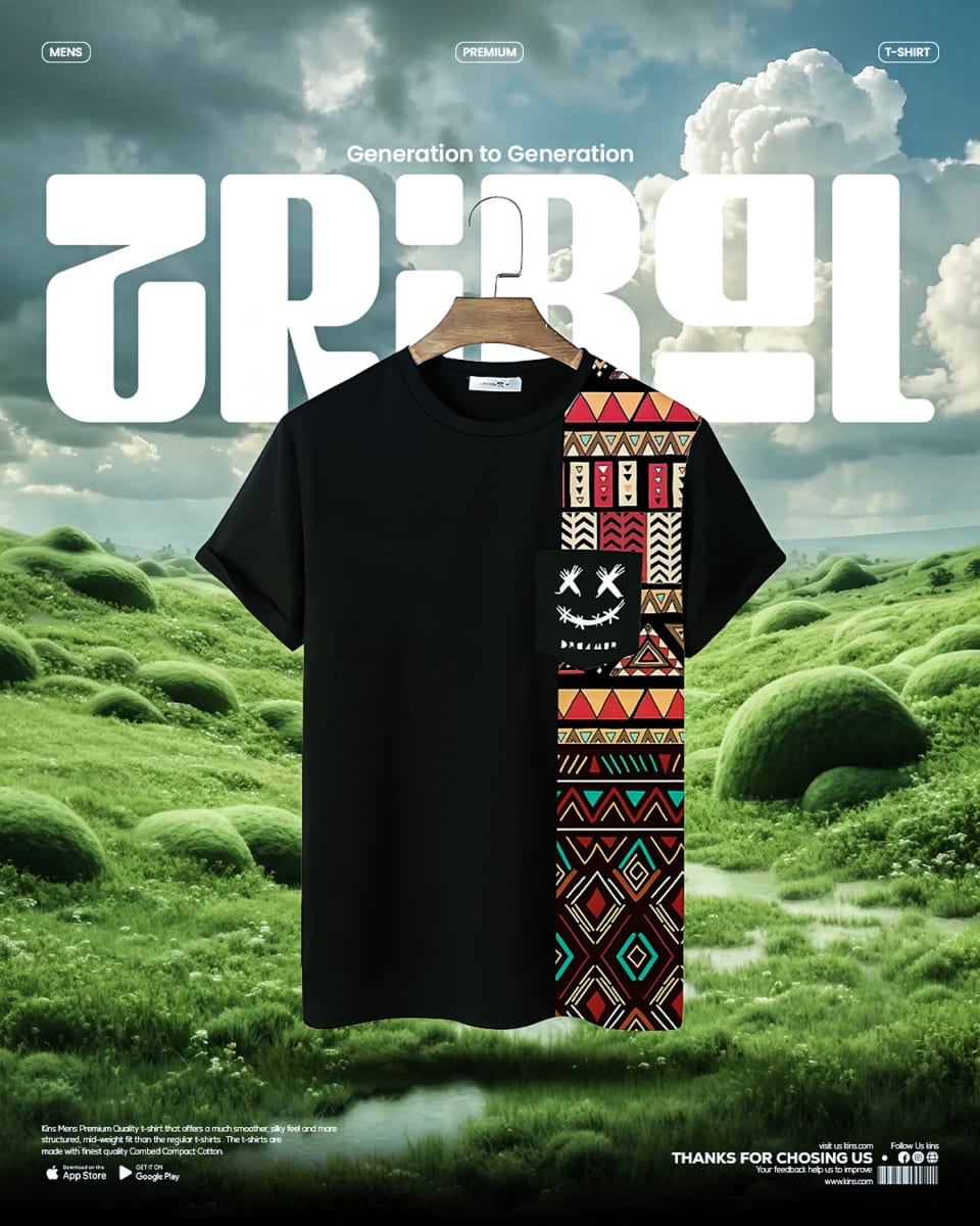 A black t-shirt with a vibrant, geometric tribal pattern panel on the right side and a smiling face graphic on the pocket, floating against a surreal landscape of rolling green, mossy hills under large white "TRIBAL" text.