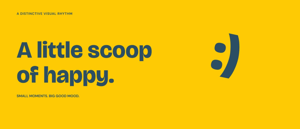 A bright yellow graphic panel displaying the MelloMe brand voice with the dark blue text "A little scoop of happy." alongside a simple, stylized sideways smiley face graphic.