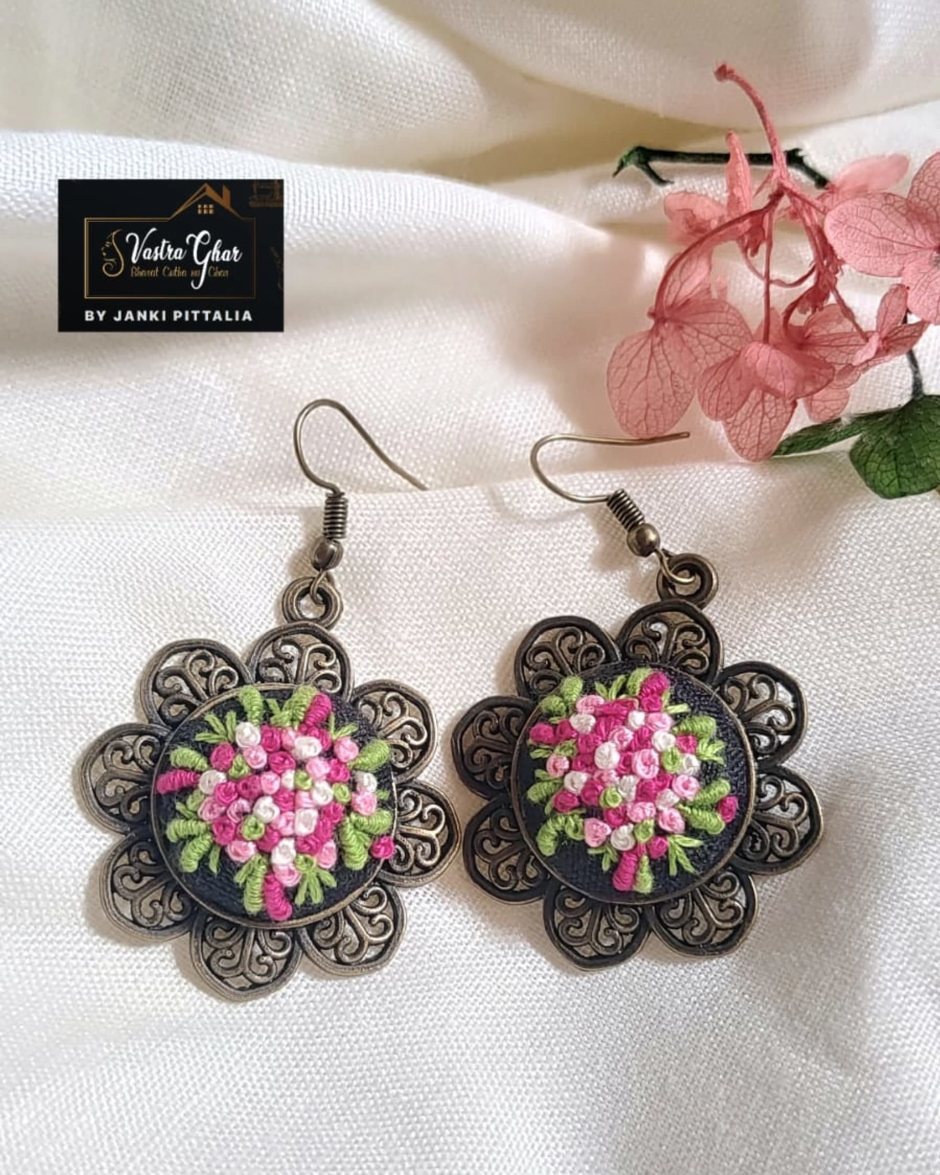 Floral bouquet embroidered earrings on white fabric