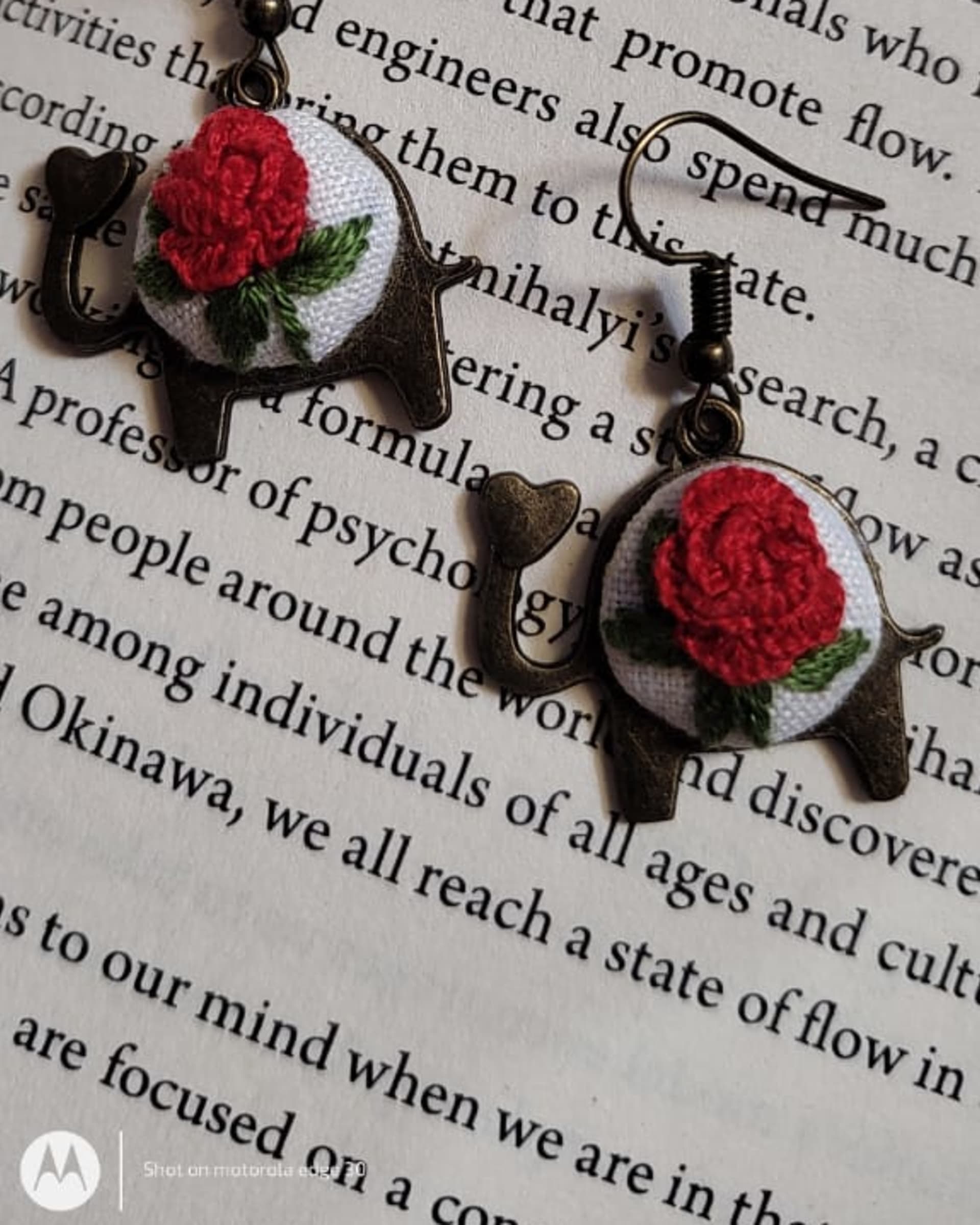 Red rose embroidered drop earrings, close-up
