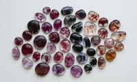 Selection of pink, red, and black fused glass pieces, arranged on a white background in a diamond formation