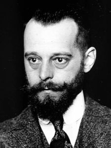 A photograph of Félix d'Hérelle. He is about 32 years old with short black hair, a moustache, and a beard.