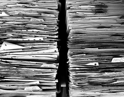 two tall stacks of files and documents