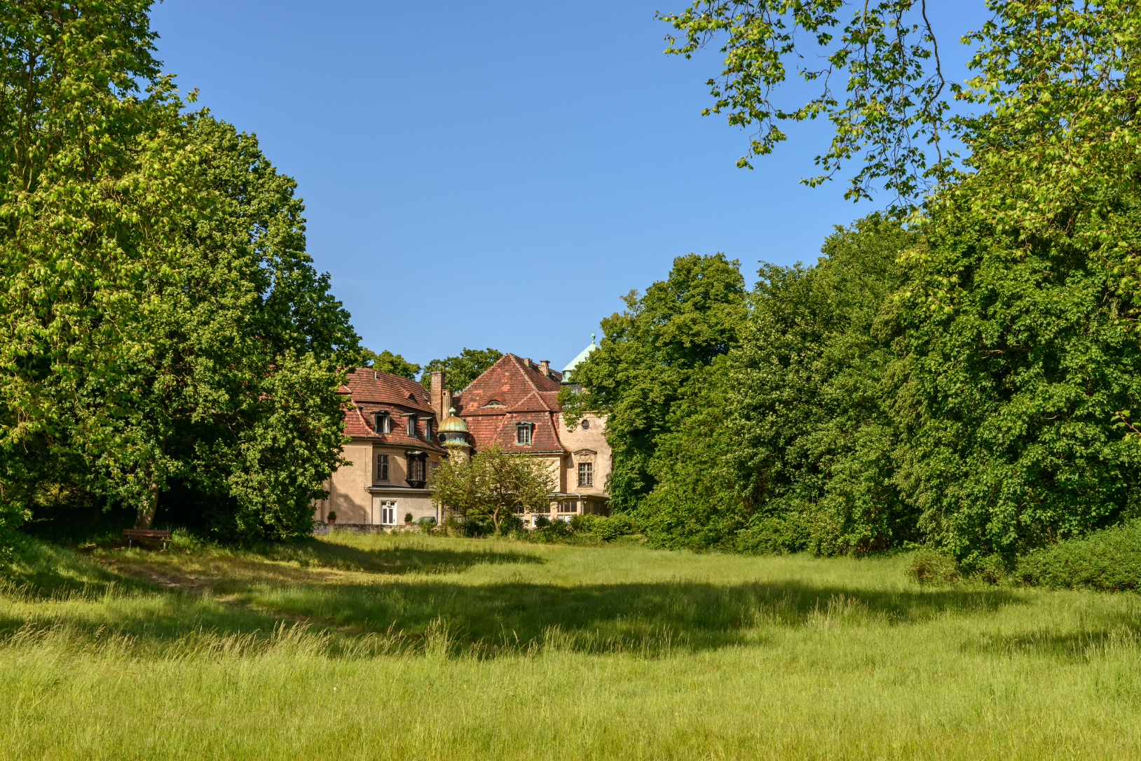 Blick durchs Grüne auf das Schloss Marquardt in Brandenburg