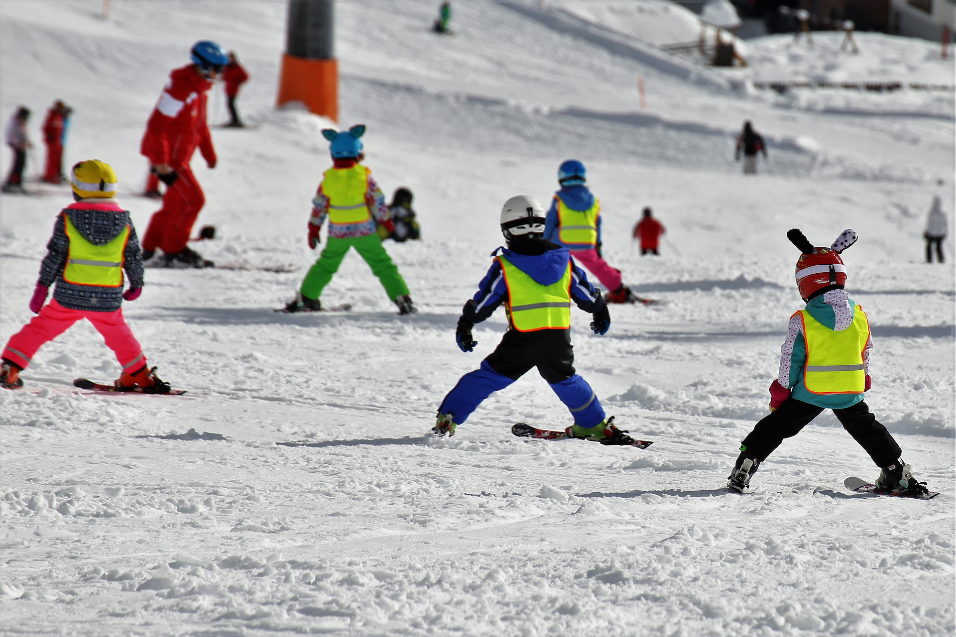 Kinder mit Skiern auf der Piste im Skikurs