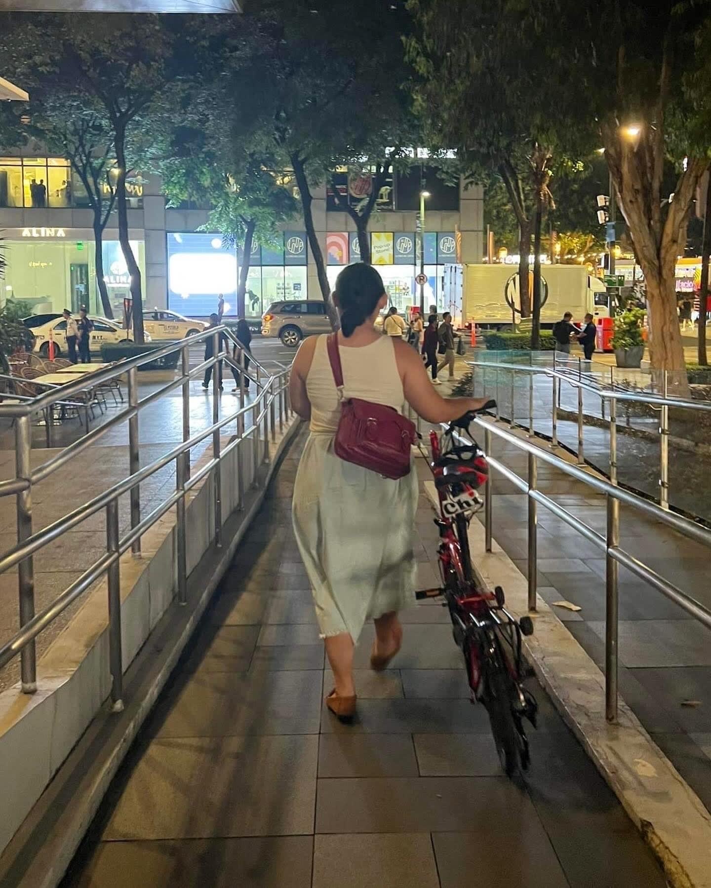 Chi walking her unfolded folding bike down the ramp at BGC
