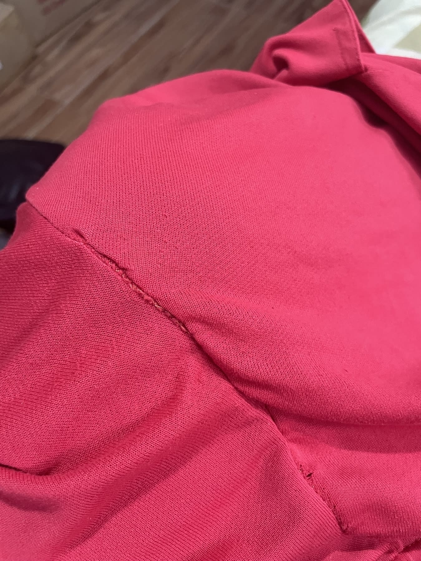 Chi’s red shorts that previously had a hole in it, now sewn back closed. Some of the threads used in her patchwork are visible, and the sewing isn’t that clean, but the hole is not present anymore.