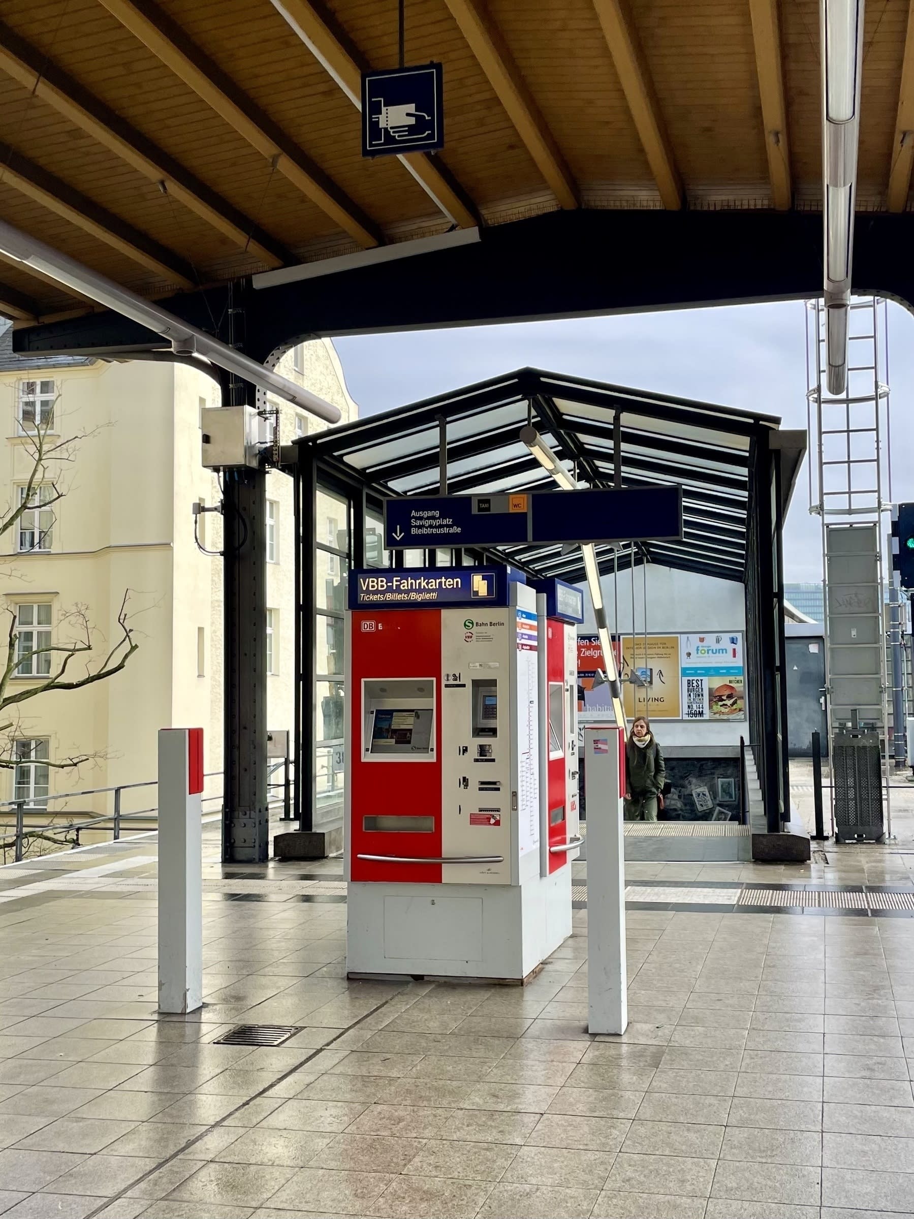 A self-service ticketing machine with two verification stands in front of the stairs leading to the entrance of the S-Bahn in Berlin.