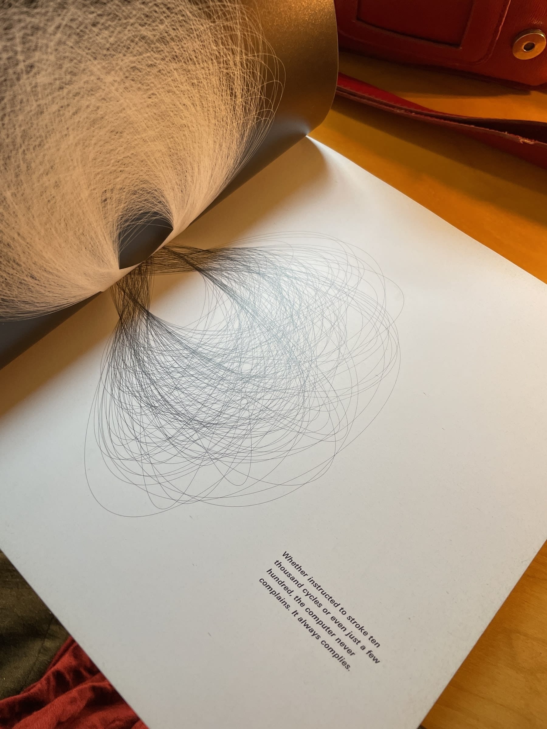 A page spread from a book where there is a drawing of an infinity loop repeatedly drawn to span both pages. The left page is colored black with white lines, while the right page—with is where the focus is—is white with black lines. There is text at the bottom right corner of the page which reads: "Whether instructed to stroke ten thousand cycles or even just a few hundred, the computer never complains. It always complies."