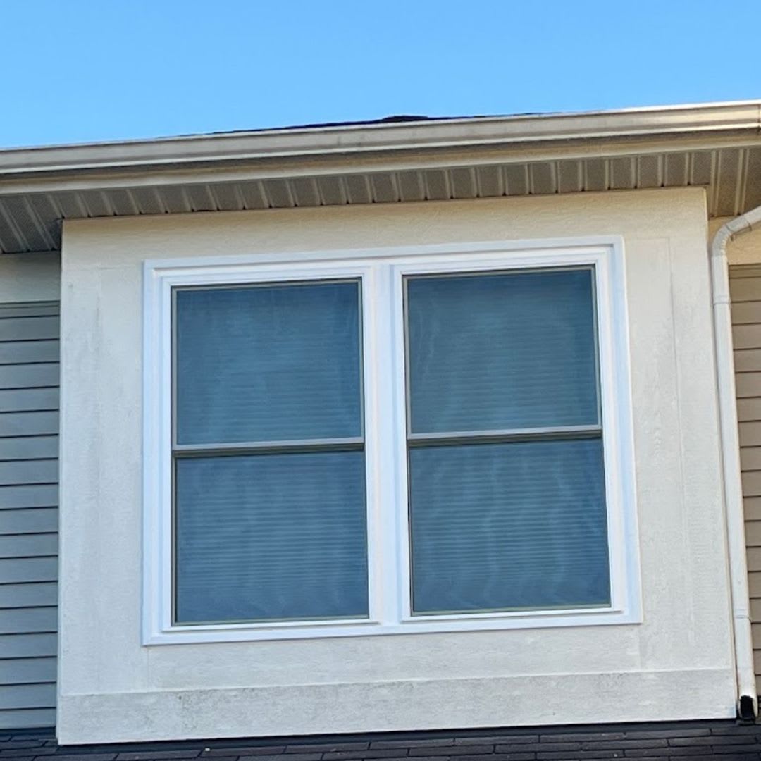 A house with two windows on the side of the house.