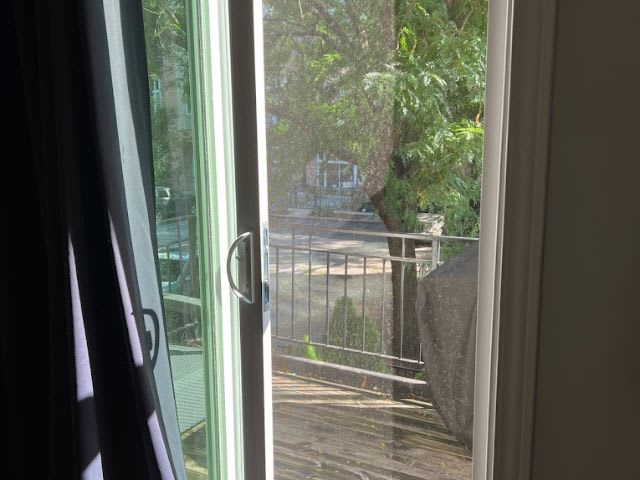 A sliding glass door in a room with a balcony.