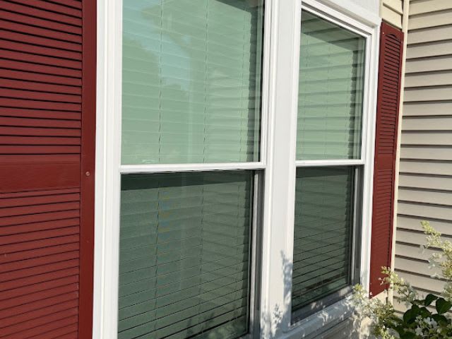 A window with red shutters and a red door.