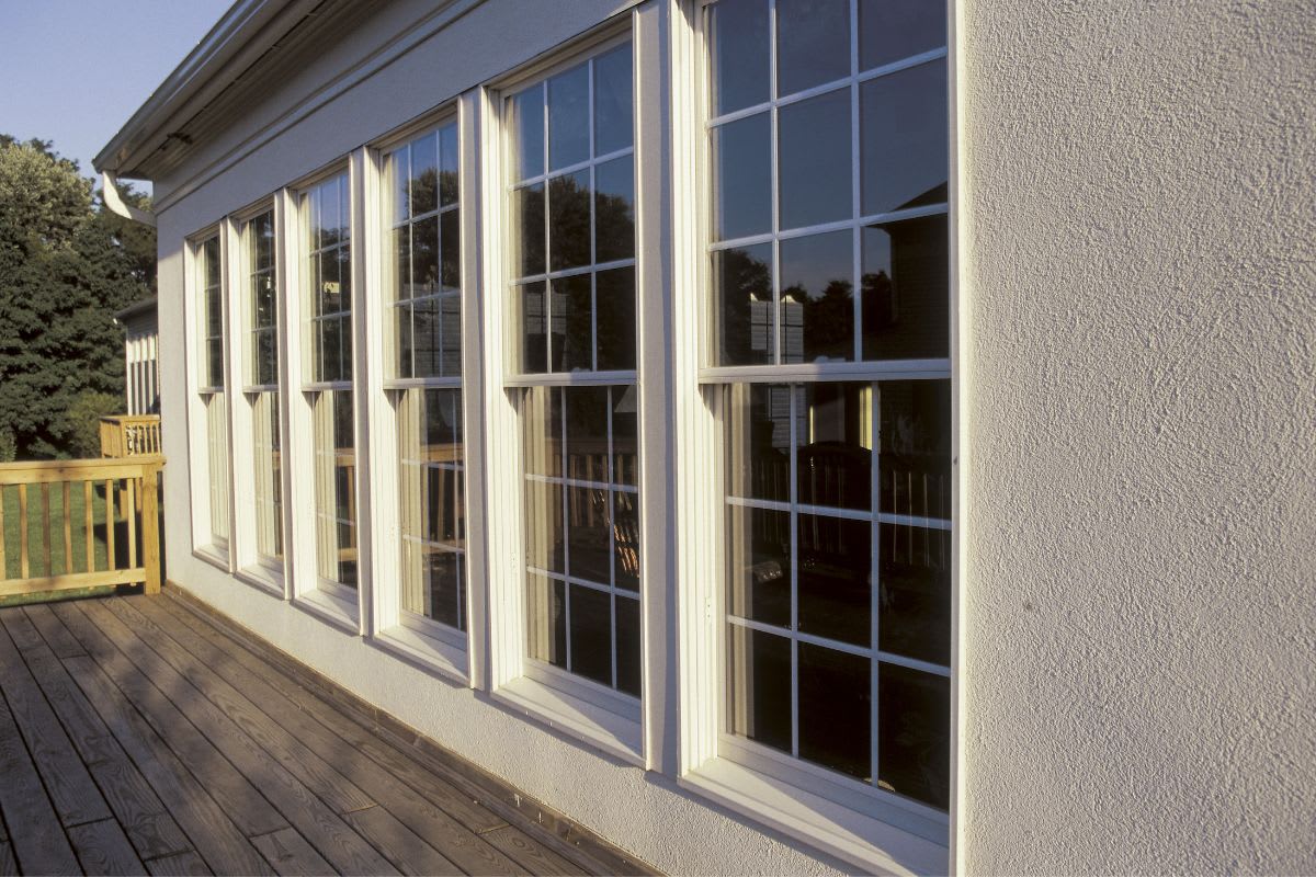 Row of windows along a residential home's side with a wooden deck.