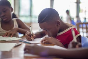 Children at table reading and writing