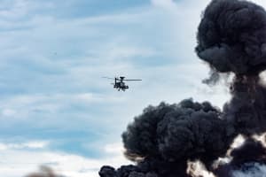 Ein Kriegsflugzeug fliegt über Rauch, der durch eine abgefeuerte Bombe entstanden wurde