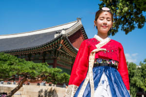 Ein Koreanisches Mädchen steht vor einem koreanischen Palats