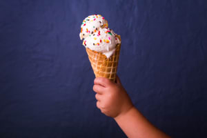 Ein Kind hält eine Glace in der Hand