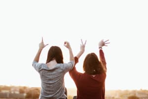 Zwei Menschen symbolisieren mit ihren Händen "Love"