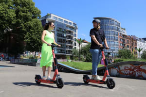 Zwei Personen fahren mit ihren E-Scooter durch die Stadt
