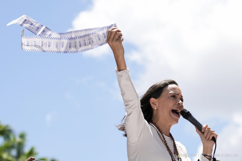 Die Oppositionsführerin Maria Corina Machado hält während einer Demonstration gegen die Wiederwahl von Präsident Nicolás Maduro einen Monat nach der umstrittenen Präsidentschaftswahl, die die Opposition ihrer Meinung nach erdrutschartig gewonnen hat, in Caracas, Venezuela, 28. August 2024, die Stimmzettel hoch.