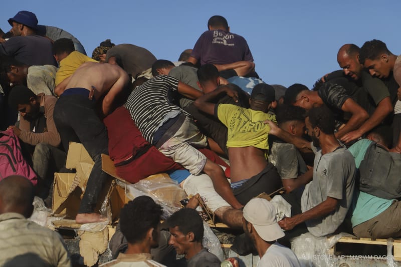 Palästinenserinnen und Palästinenser fahren auf einem mit Lebensmitteln und humanitärer Hilfe beladenen Lastwagen durch den Morag-Korridor in der Nähe von Rafah im südlichen Gazastreifen, Montag, 4. August 2025.