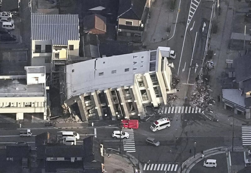 Ein Gebäude fällt nach einem Erdbeben in Wajima, Präfektur Ishikawa, Japan, Dienstag, 2. Januar 2024, auf den Boden.