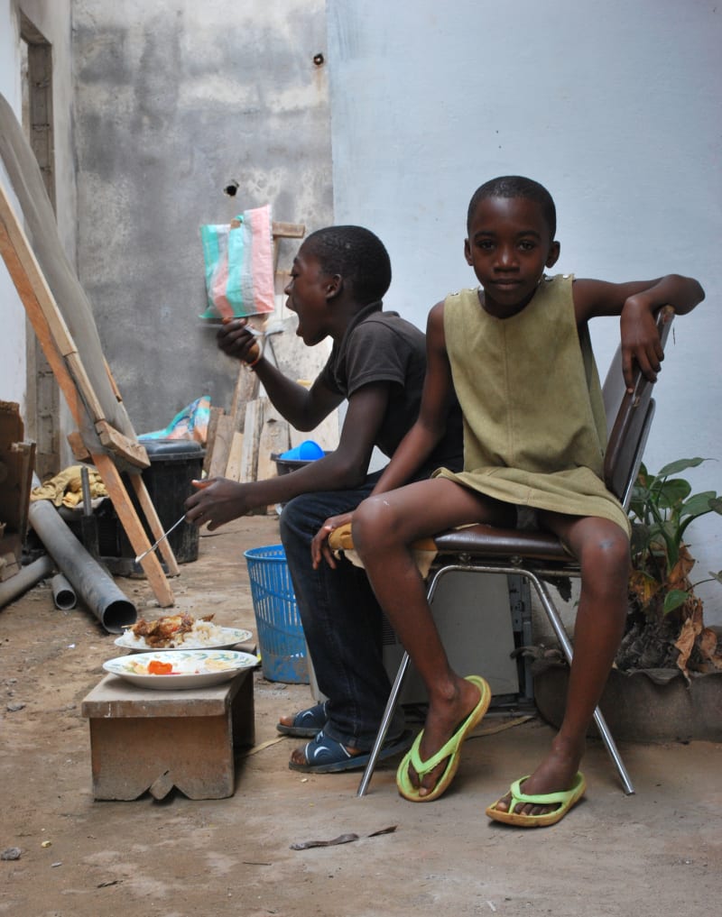Adeline aus Kamerun sitzt auf einem Stuhl.