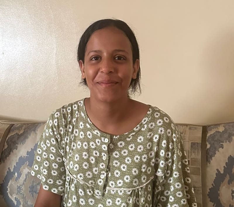 Sowohl Kinder als auch Erwachsene schauen zu, wie ein junger Golfer auf einem Golfplatz einen Putt spielt.