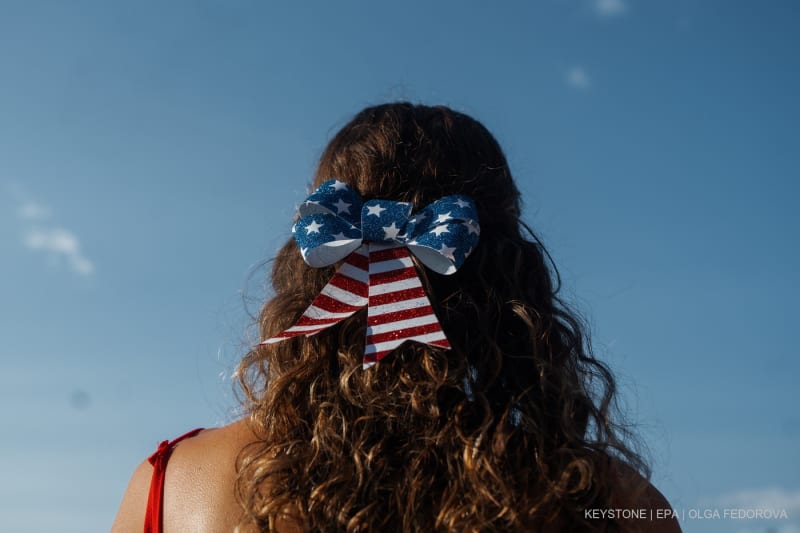 Eine Frau trägt eine Schleife in den Farben der US-Flagge, während sie auf das jährliche Feuerwerk zum Unabhängigkeitstag in New York, New York, USA, am 4. Juli 2025 wartet.