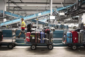 Ein Mitarbeiter scannt und platziert das Gepack in Waggons oder Containern, um die Koffer von der neuen Gepacksortieranlage des Flughafens Zuerich zu den Flugzeugen zu transportieren, fotografiert am Donnerstag, 25. Juli 2024 in Kloten.