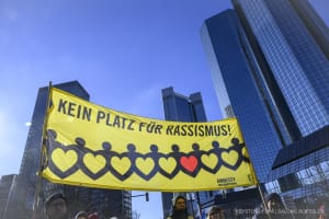 Kein Platz für Rassismus steht auf dem Plakat direkt vor den Türmen der Deutschen Bank.