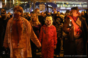 Leute in gruseligen Kostümen machen am Donnerstag, dem 31. Oktober 2024, bei einem Halloween-Zombie-Protestmarsch in der Innenstadt von Essen mit.
