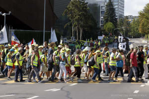 Demonstranten der Bewegung „Gilets Jaunes“ (Gelbwesten) halten Transparente, als sie auf dem Place des Nations vor dem europäischen Hauptsitz der Vereinten Nationen in Genf, Schweiz, ankommen, Samstag, 31. August 2019.